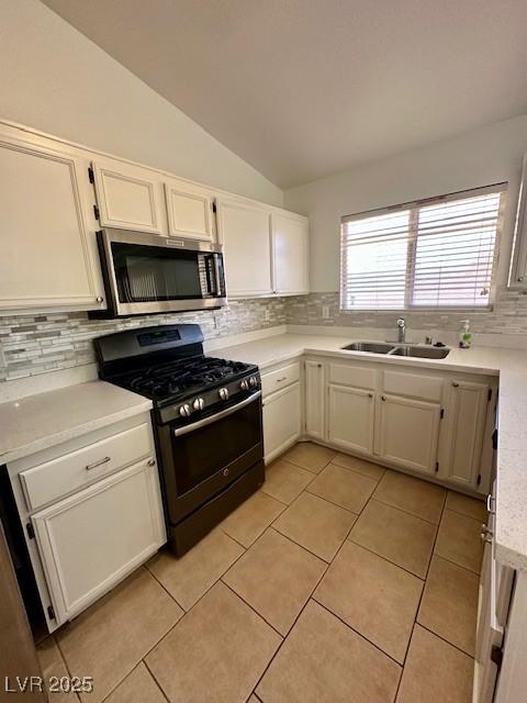 kitchen featuring tasteful backsplash, lofted ceiling, black gas stove, and sink