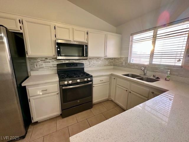 kitchen featuring sink, white cabinetry, backsplash, stainless steel appliances, and light tile patterned flooring