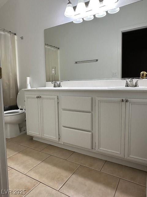 bathroom featuring vanity, tile patterned floors, and toilet