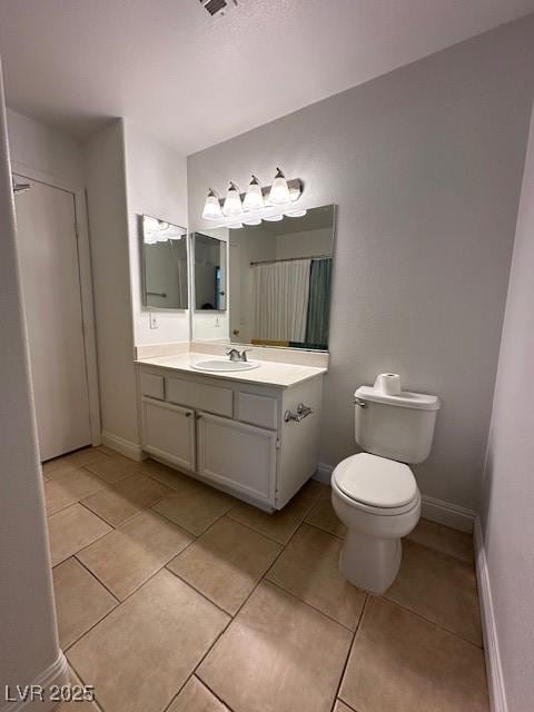 bathroom featuring vanity, tile patterned floors, and toilet