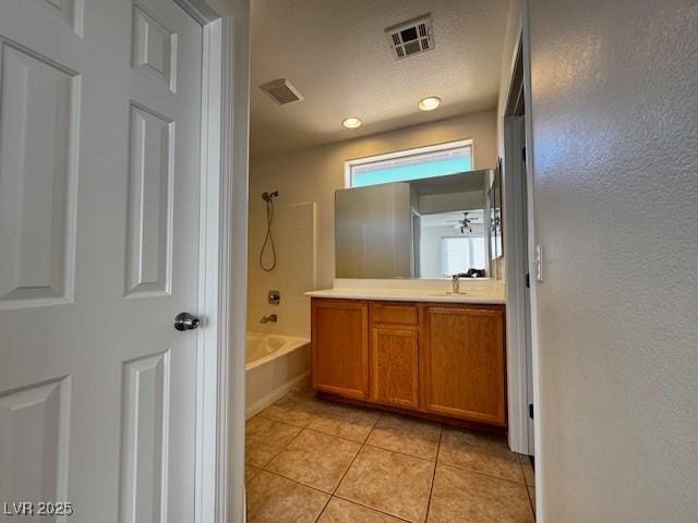 bathroom with tile patterned flooring, vanity, tub / shower combination, and a textured ceiling