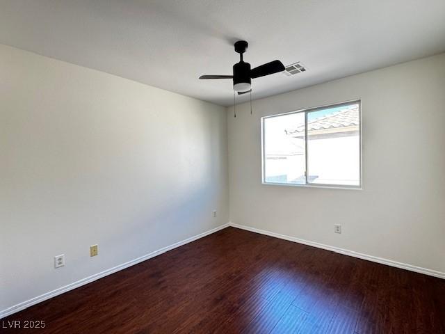 spare room featuring ceiling fan and dark hardwood / wood-style flooring