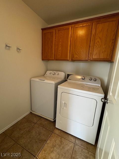 laundry area featuring tile patterned floors, cabinets, and washing machine and clothes dryer