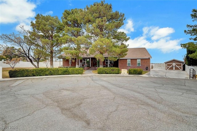 ranch-style house with a garage and an outbuilding