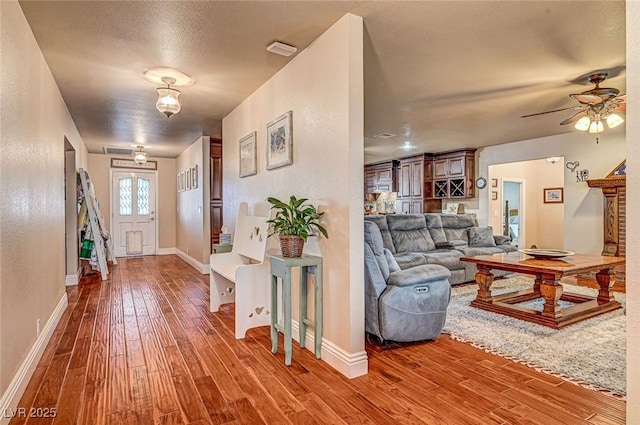 interior space featuring hardwood / wood-style flooring, ceiling fan, and a textured ceiling