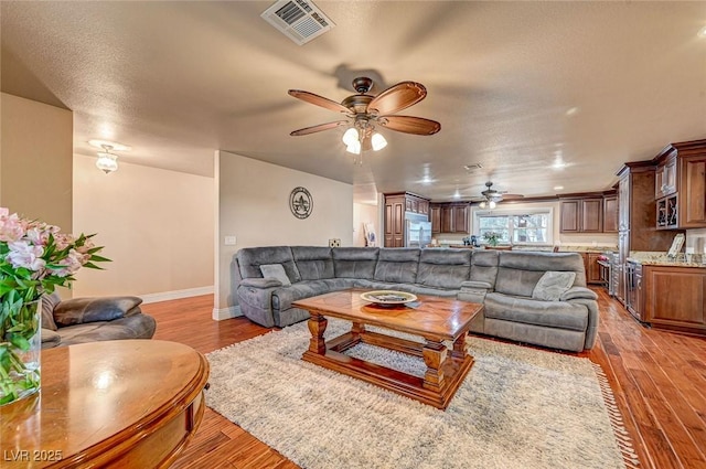 living room with ceiling fan and light hardwood / wood-style floors