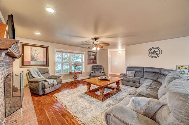 living room with ceiling fan, hardwood / wood-style floors, and a fireplace