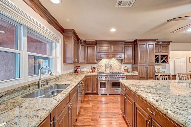 kitchen with appliances with stainless steel finishes, light stone countertops, and sink