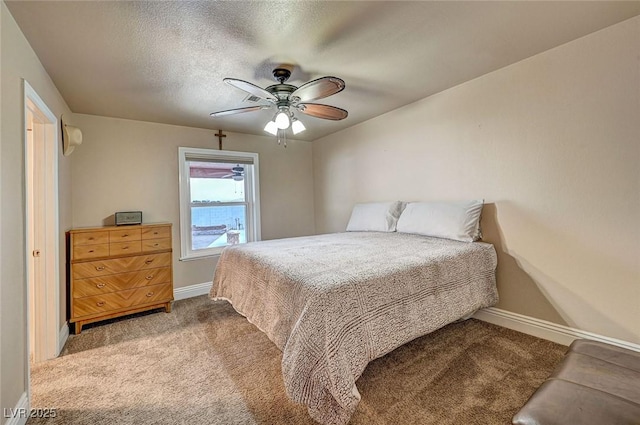 bedroom featuring ceiling fan, carpet flooring, and a textured ceiling