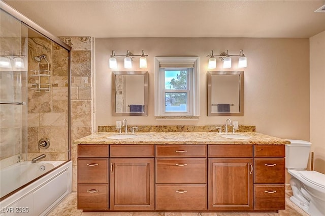 full bathroom featuring vanity, combined bath / shower with glass door, and toilet