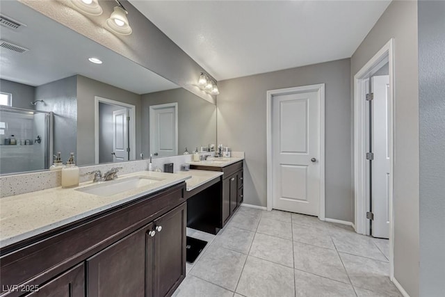 bathroom with vanity, a shower with door, and tile patterned floors