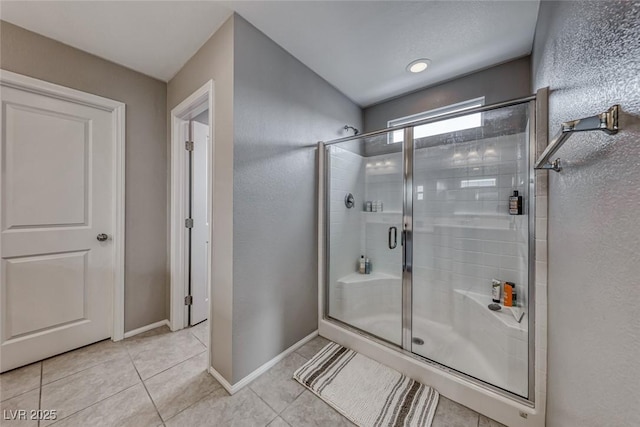 bathroom with tile patterned flooring and a shower with shower door