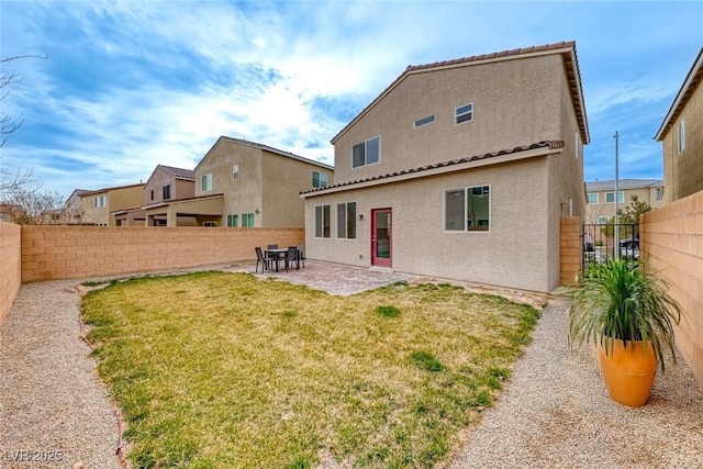 back of property with a yard and a patio area