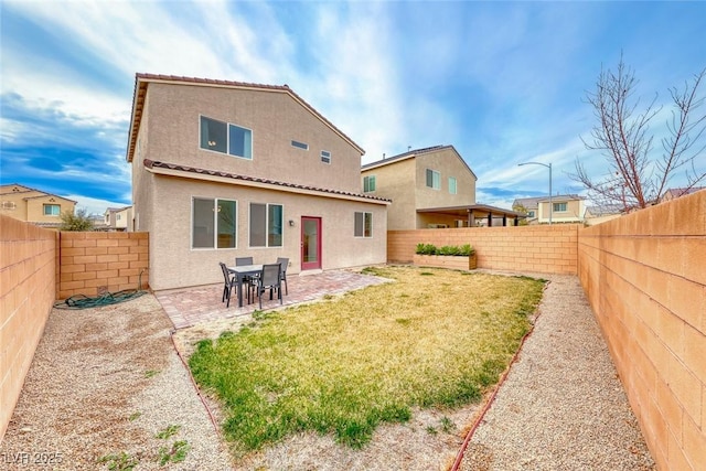 back of property with a patio and a lawn