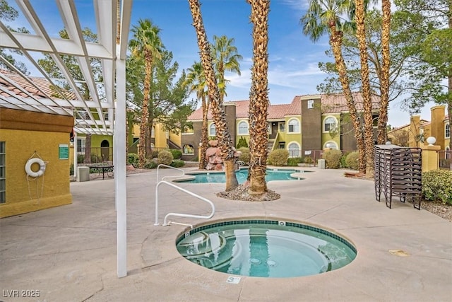 view of swimming pool with a community hot tub, a pergola, and a patio area