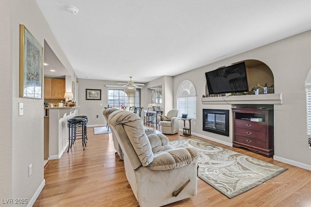 living room with ceiling fan and light wood-type flooring