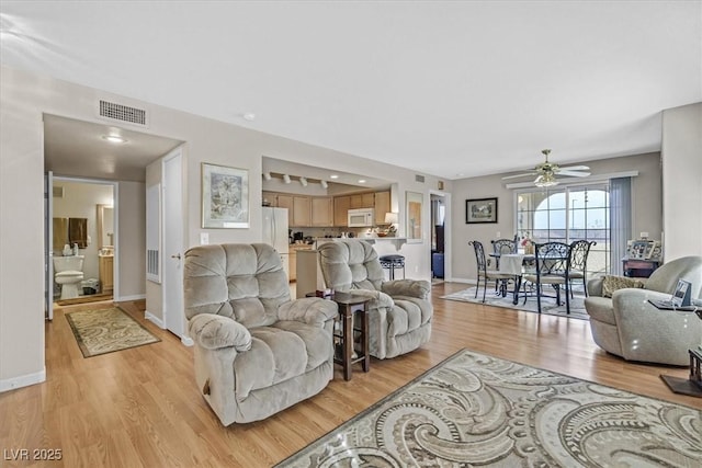 living room with ceiling fan and light hardwood / wood-style flooring