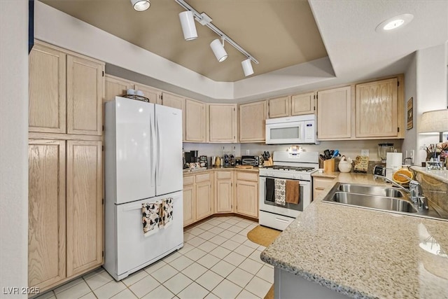 kitchen with sink, white appliances, light stone countertops, a raised ceiling, and light brown cabinets