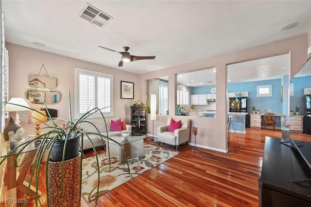 living room featuring hardwood / wood-style floors and ceiling fan