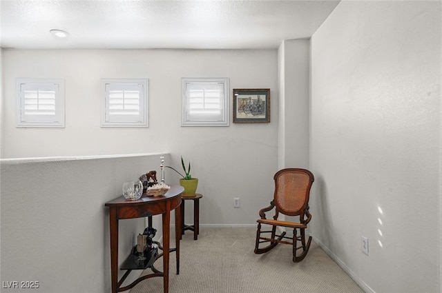 sitting room featuring light colored carpet