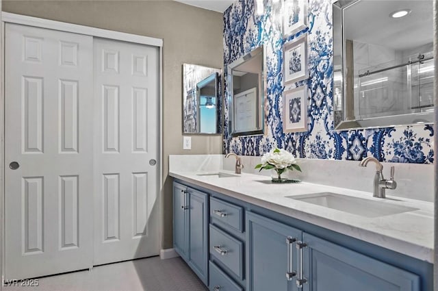 bathroom featuring a shower with door and vanity