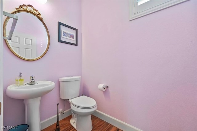 bathroom with hardwood / wood-style flooring and toilet