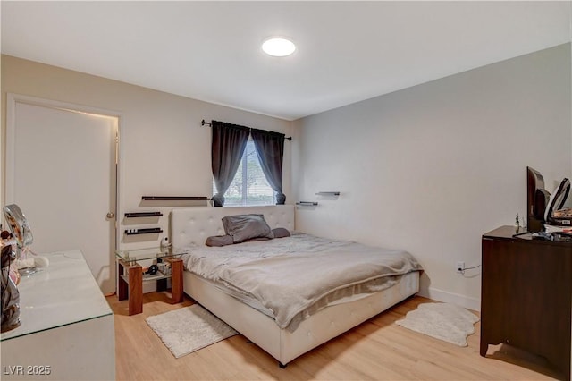 bedroom featuring wood finished floors and baseboards