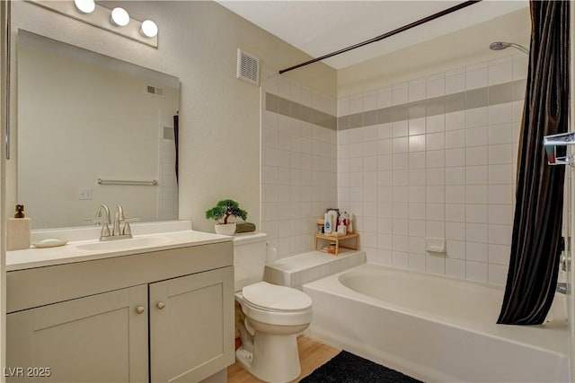 bathroom with visible vents, toilet, wood finished floors, shower / bathtub combination with curtain, and vanity