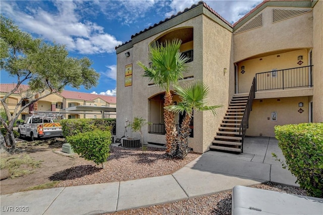 view of property with central AC and stairs