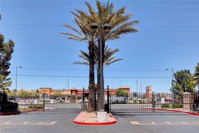 view of road with a gate, curbs, and a gated entry