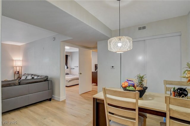 dining area featuring light wood-type flooring and visible vents