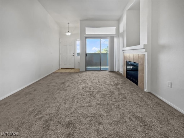 unfurnished living room featuring carpet and a tiled fireplace