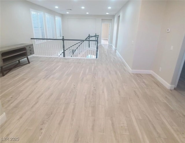 unfurnished room with light wood-style flooring, baseboards, and recessed lighting