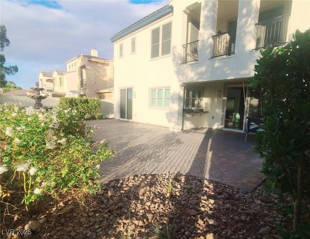 back of property featuring a patio and stucco siding