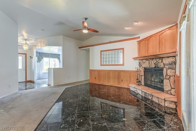 kitchen with vaulted ceiling, carpet flooring, ceiling fan, and a fireplace