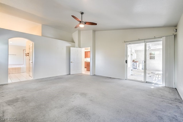 unfurnished room featuring vaulted ceiling, light carpet, and ceiling fan