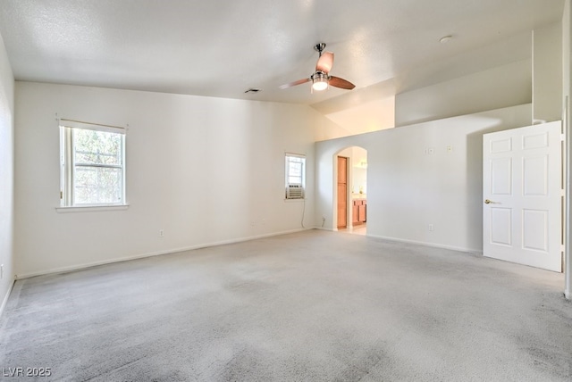 empty room featuring vaulted ceiling, ceiling fan, light colored carpet, and cooling unit