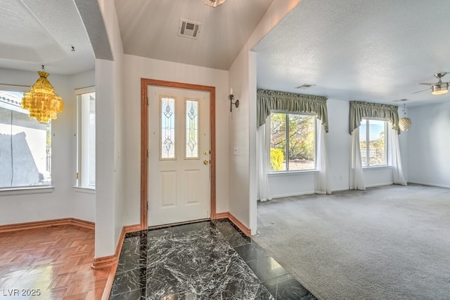 foyer with a textured ceiling and carpet