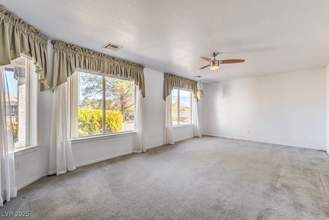 unfurnished room with ceiling fan, carpet, and a textured ceiling