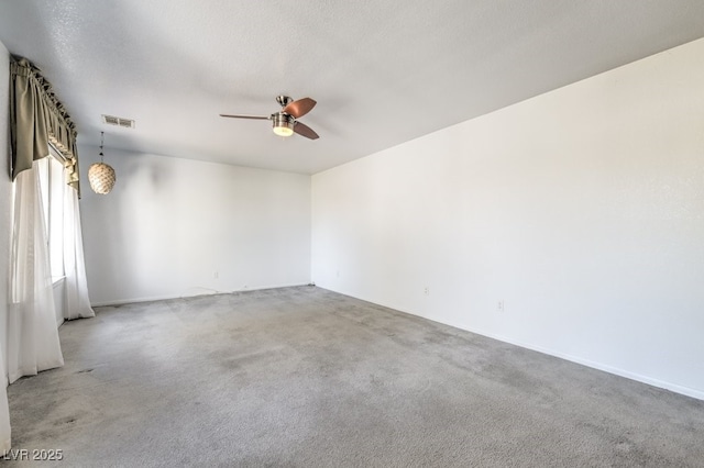 unfurnished room featuring a textured ceiling, carpet floors, and ceiling fan