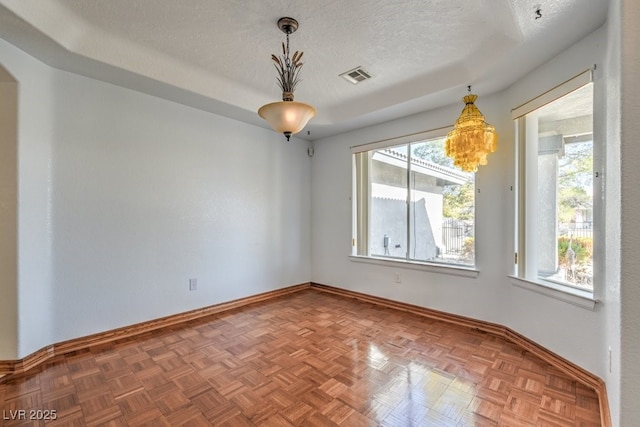 spare room featuring parquet floors and a textured ceiling