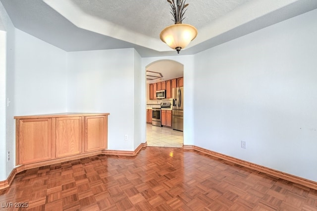 unfurnished room with a textured ceiling and light parquet floors