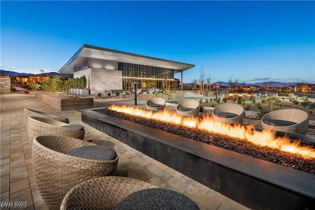 patio terrace at dusk with a mountain view and a fire pit