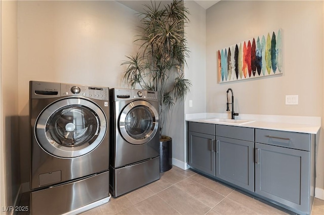 clothes washing area with light tile patterned flooring, sink, and washer and clothes dryer