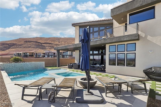 view of pool featuring an in ground hot tub, a mountain view, and a patio area