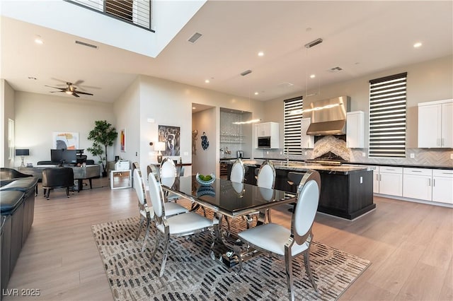 dining room with ceiling fan and light wood-type flooring