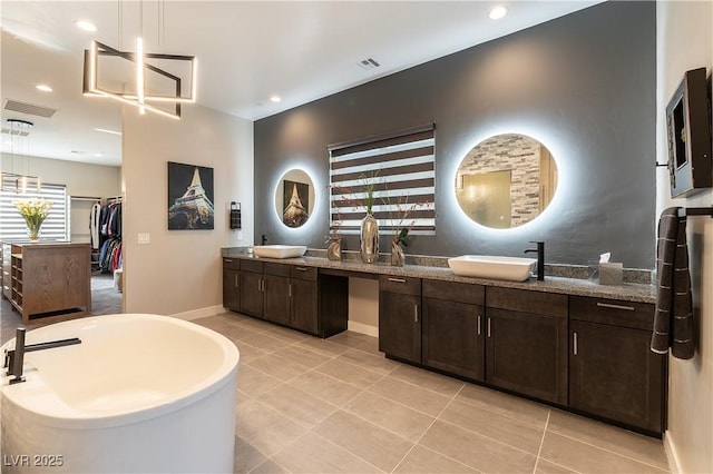 bathroom featuring tile patterned flooring, vanity, and a tub