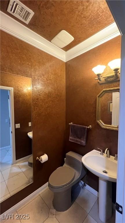 bathroom featuring tile patterned flooring, ornamental molding, and toilet