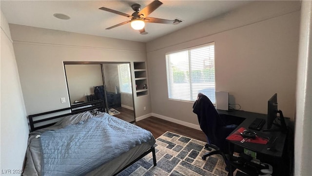 bedroom with dark wood-type flooring, ceiling fan, and a closet