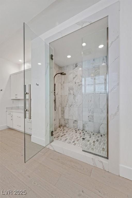 bathroom featuring recessed lighting, a stall shower, vanity, wood finished floors, and baseboards